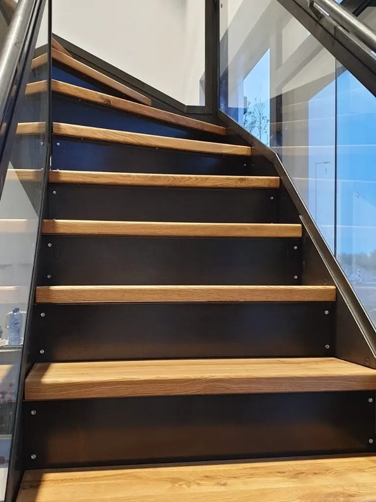 Escalier quart tournant aux marches en chêne, le long d’une verrière