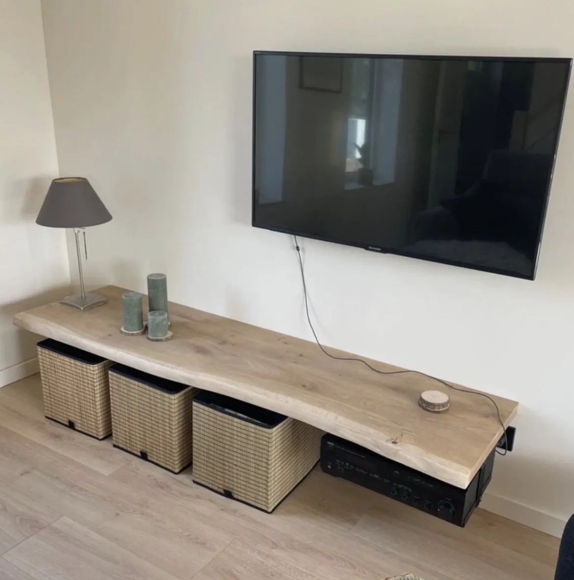 Planche en chêne à bord naturel posée en dessus de meuble TV, sous un téléviseur